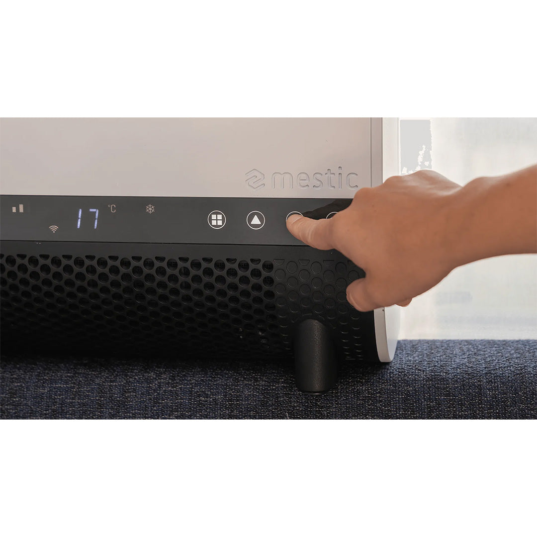 Hand using the touch control panel and temperature display on the Mestic SPA-3100 air conditioner